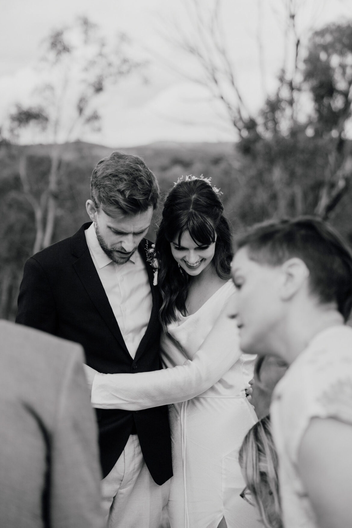 A bride and groom cuddle as their guests witness the wedding certificate