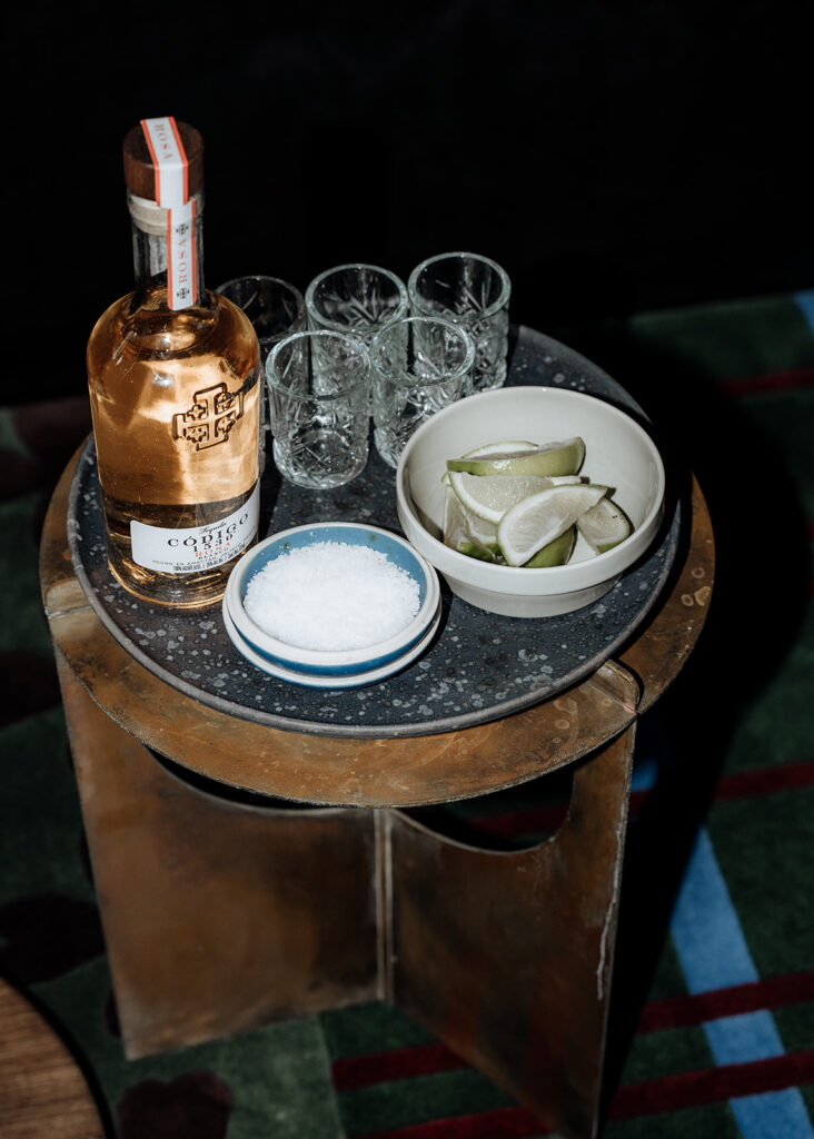 Tequila and limes are set up on a table in preparation for an intimate wedding ceremony in an Airbnb in Hobart, Tasmania