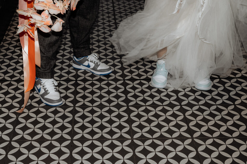 A bride and groom both wear Nike sneakers to their glamourous wedding elopement